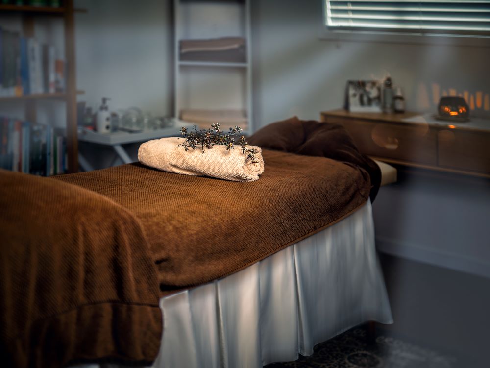 massage-table-with-towels-and-candle-in-a-cabinet tocuh by trans